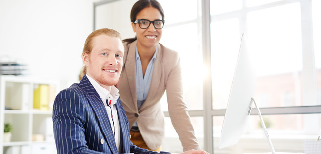Portrait of business team using computer together at office
